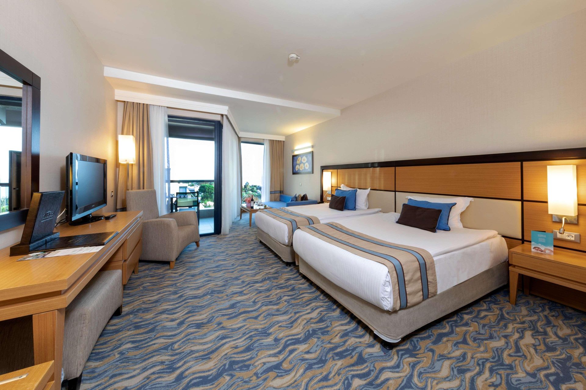 Buồng ngủ phòng senior suite trong khách sạn 4-5 sao gồm có giường, kệ, tivi, vỏ gối,..